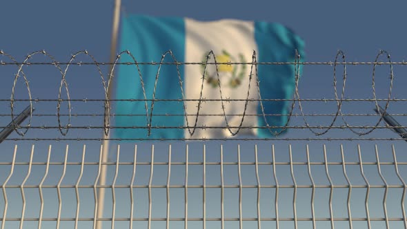 Waving Flag of Guatemala Behind Barbed Wire