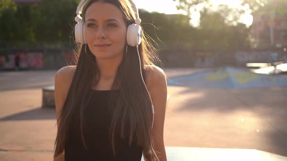 Young woman at skate park listening to music