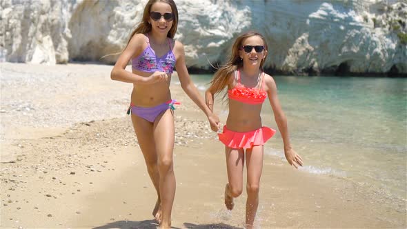 Little Happy Funny Girls Have a Lot of Fun at Tropical Beach Playing Together, Sunny Day with Rain