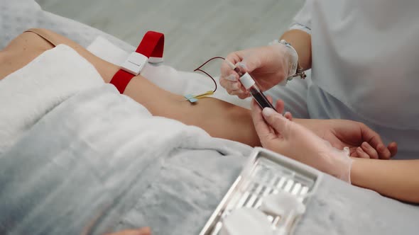 Nurse Taking a Blood Sample From a Patient Lying in a Hospital Ward