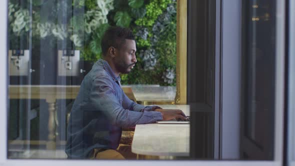 African american businessman using laptop in cafe