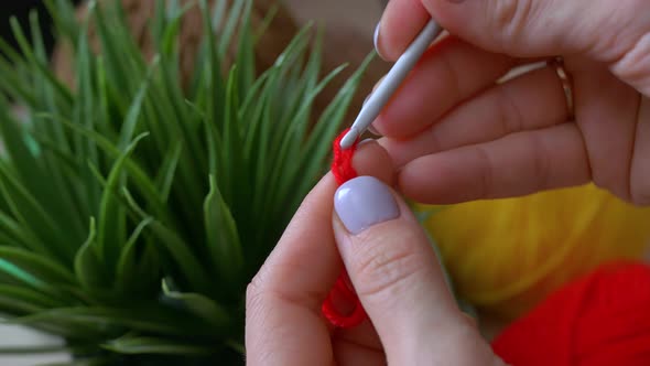 The Girl Makes the First Knots Crocheted Red Color