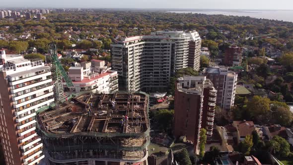 beautiful circular drone flight over the skyscrapers and construction cranes near the oceans waterfr