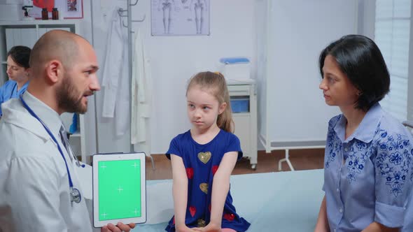 Doctor Talking and Holding a Green Screen Tablet