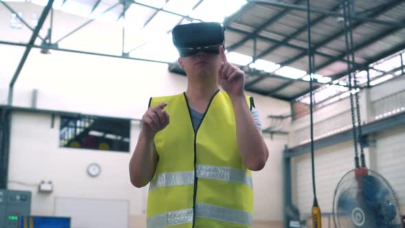 Industrial Factory Worker Wearing VR Goggle Touching in Virtual Reality World Inside Factory