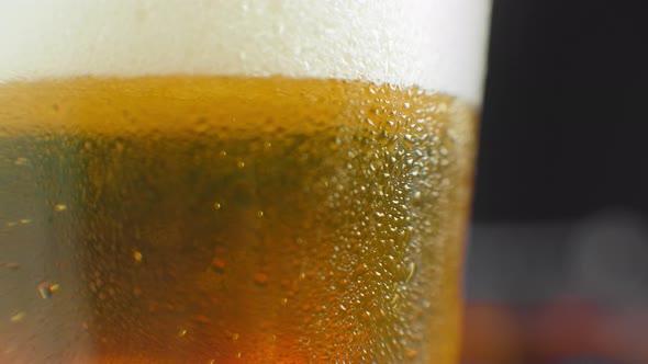 Macro Shot of a Beer Glass with Cold Beer, Bubbles Rise in the Glass. Slow Motion Beer Bubbles.