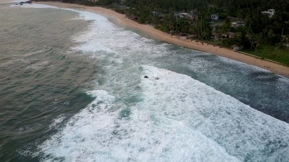 Foaming Ocean Waves Roll on Coastline with Sandy Beaches