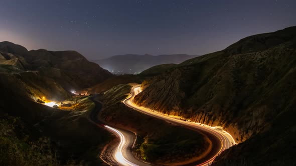 Night time lapse of a road winding through the mountains