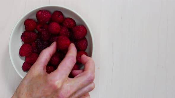 Hand Takes Raspberry Fruit from Bowl. Timelapse 
