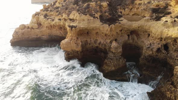 Aerial 4K drone footage revealing the rocky coastline cliffs near city of Carvoeiro, Portugal