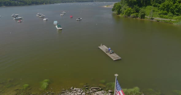 Pedestal Down and Tilt Up Boats Anchored on Harbor and Flag Swaying in the Wind