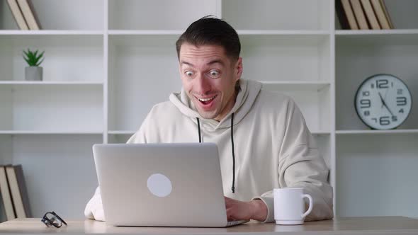 Successful Man Freelancer Sits at Table with Laptop Working at Modern Office