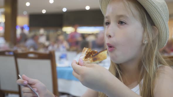 A Young Girl with Plaits Is Eating a Piece of Pizza. Charming Happy Young Girl Laugh and Biting Off