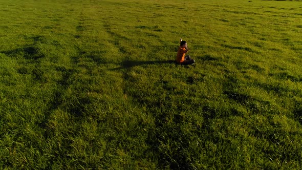 Low Altitude Radial Flight Over Sport Yoga Man at Perfect Green Grass. Sunset in Mountain.