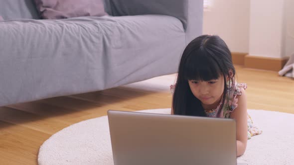 Asian girl using computer laptop playing game and social media or chatting with her friends.