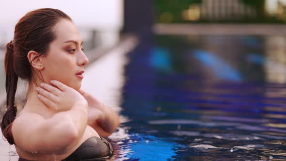 Asian young woman relaxing in swimming pool at luxury hotel