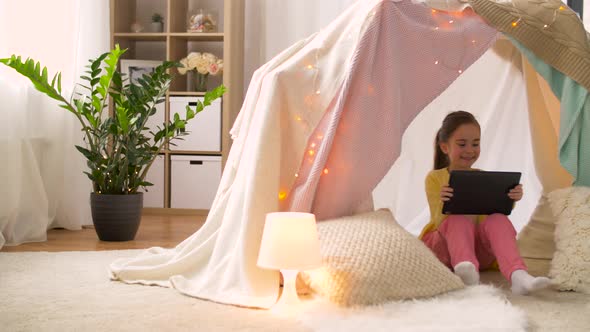 Little Girl with Tablet Pc in Kids Tent at Home