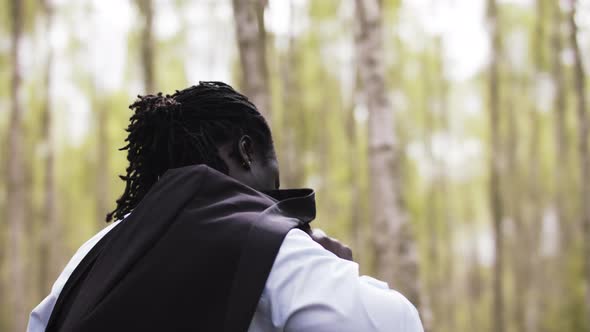 Successful African Businessman Putting His Suit Over the Shoulder in the Park