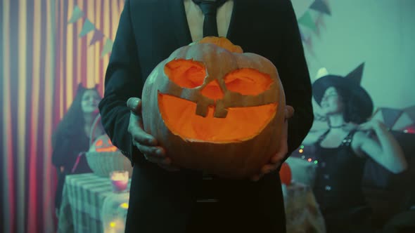 Closeup of an Unrecognizable Guy Holding a Jacko'lantern for Halloween