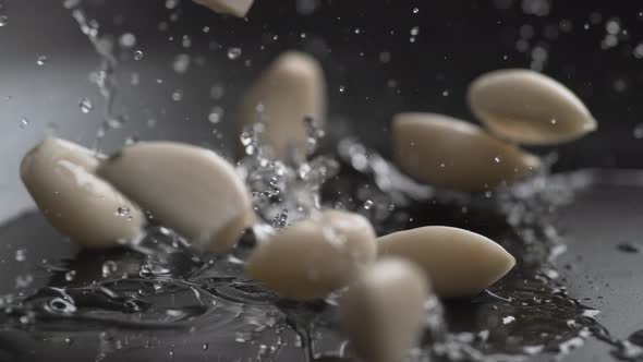 Putting clove of garlics into heated oil on fry pan. Slow Motion.