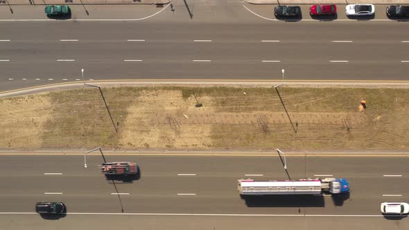 A top down view directly over a highway median on a sunny day. With traffic on either side of the gr