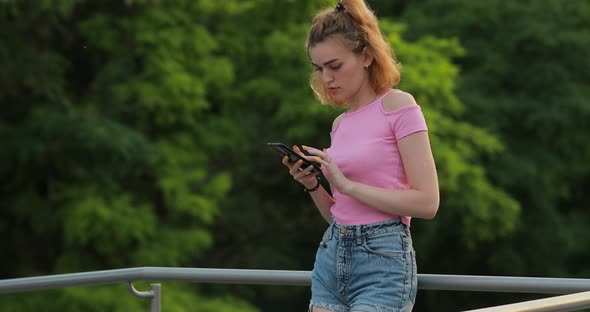 Woman Using Phone in a Park