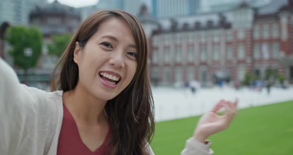 Woman take selfie and hold a camera in Tokyo station 