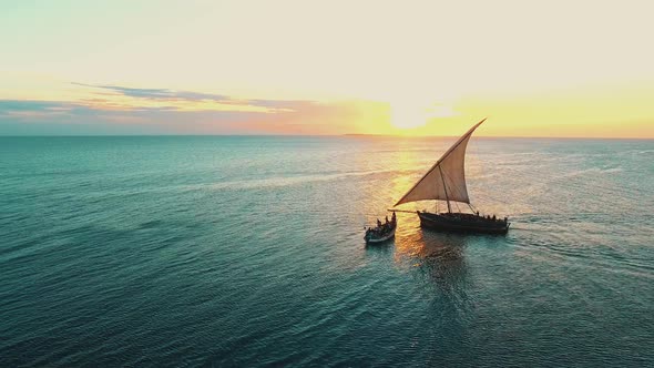 fishermen's wooden dhow sailing at sunset in Zanzibar