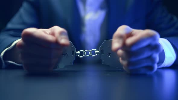 Arrested Criminal Businessman in Handcuffs in the Interrogation Room