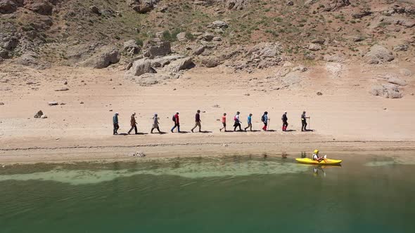 People Walking By The Lake And Canoeing On The Lake