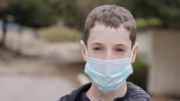 Coronavirus pandemic close up on boy face wearing face mask to avoid contagion