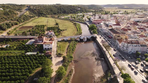 Aerial dolly following the river beside a historic town of Silves in Portugal