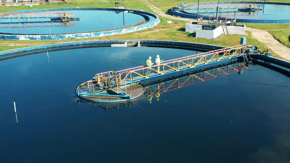 Top View of a Wastewater Reservoir Getting Observed By Specialists