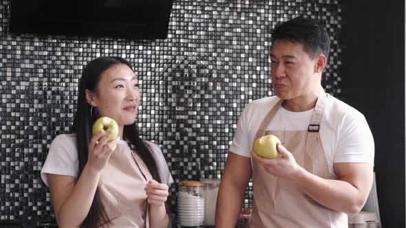 Portrait of Happy Young Asian Couple Cooking Together in the Kitchen at Home