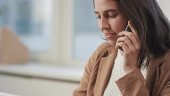 Manager Talking On Phone And using Laptop