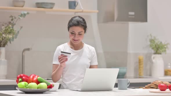 Indian Woman Making Online Payment on Laptop in Kitchen