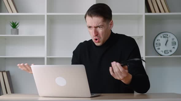Portrait of Shocked Male Businessman Looking at Laptop Takes Off Glasses and Say What