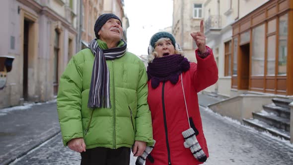 Senior Old Couple Tourists Man Woman Family Walking Talking Gesturing on Winter Snowy City Street