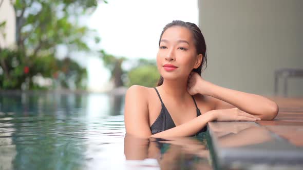 Young asian woman enjoy around outdoor swimming pool for leisure