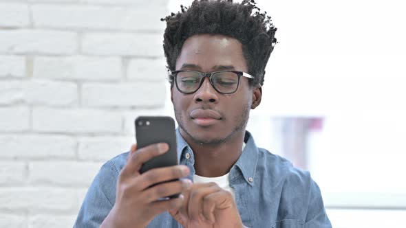 Ambitious Young African Man Using Smartphone 