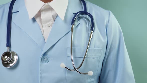 Doctor in Professional Medical Suit with Stethoscope and Blue Gloves Corrceting Clothes