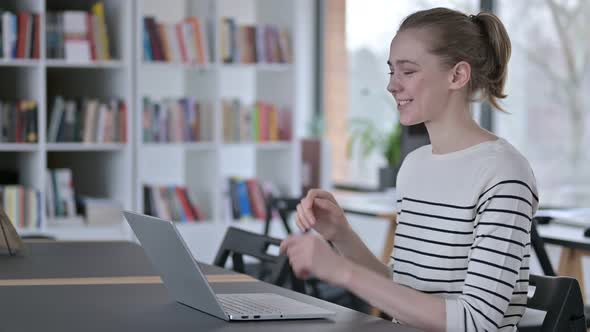 Video Chat on Laptop By Young Woman in Library 