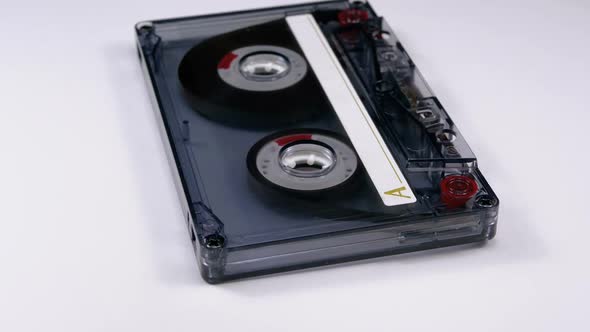 Vintage Transparent Audio Cassette Rotates on White Background