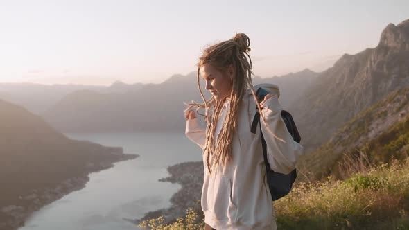 Young  hipster millennial dreadlocks woman walking trough the mountain