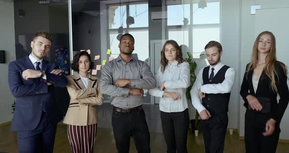 Smiling Multiethnic Business Group Posing with Arms Crossed with Leader Foreground Showing Team