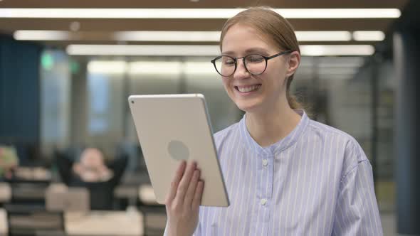 Portrait of Video Call on Tablet By Young Woman in Office