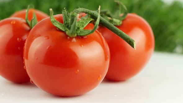 Ripe natural tomatoes close-up. Organic tomato rotating on a green background Macro shot.