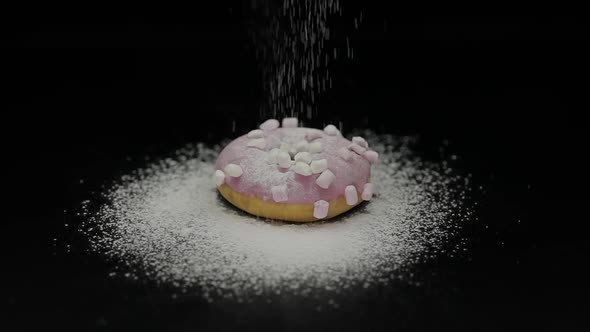 Tasty Fresh Donut Lay on Black Surface and Gets Sprinkle with Icing Sugar Powder