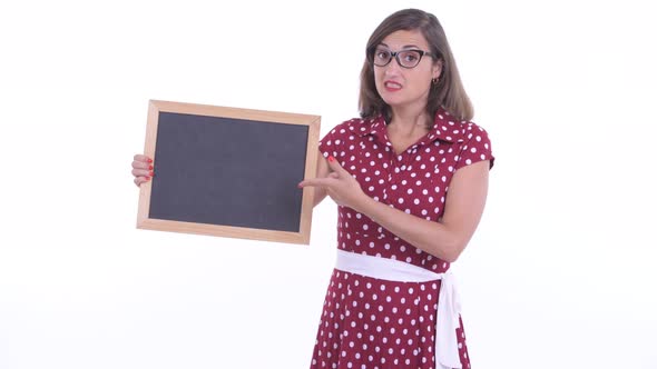 Stressed Woman with Eyeglasses Holding Blackboard and Giving Thumbs Down