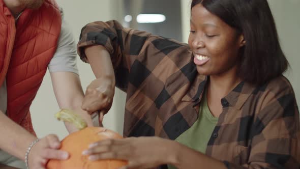 A Handsome Young Lady is Carving the Pumpkin